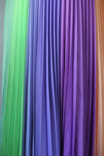 Load image into Gallery viewer, Green, lilac, purple and orange shades blend in this close up shot of the pleats in this joyful pleated skirt, part of the Kitty Joseph Pastel Collection.