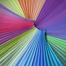 Load image into Gallery viewer, The Pastel skirt photographed from above, with it's pleats fanning outward. This photograph shows the full range of shades in this multicoloured, joyful pleated skirt.