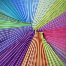 Load image into Gallery viewer, The mood-boosting, colourful Pastel Skirt laid flat, with pleats fanning in all directions. A shot that shows the full spectrum of shsdes in this joyful multicolour design.