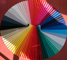 Load image into Gallery viewer, Chroma skirt laid out flat with fanning pleats in a rainbow spectrum design. Mood boosting and uplifting fashion for all body shapes