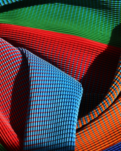 Charger l'image dans la galerie, Close-up of KittyJoseph Parrot Dress fabric showing fine crystal pleats in vibrant green, red, orange, and blue hues.
