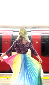 Happy customer Twinks twirls joyfully in her new pastel skirt, revealing it's many uplifting colours, pleats and a-line silhouette. She styles beautifully it with a sequin top and hat from her own wardrobe.